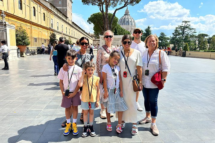 Adults and children standing in a Vatican Museums courtyard