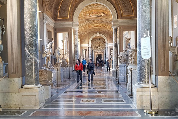 Marble columns and sculptures in a Vatican Museums gallery