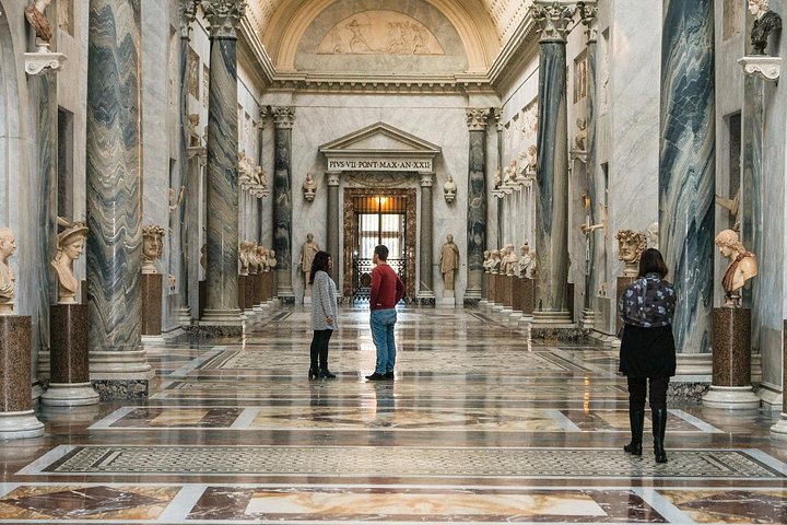 Visitors in a marble gallery at the Vatican Museums