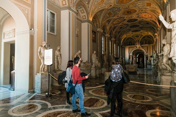 A small party exploring a decorated Vatican museum hall