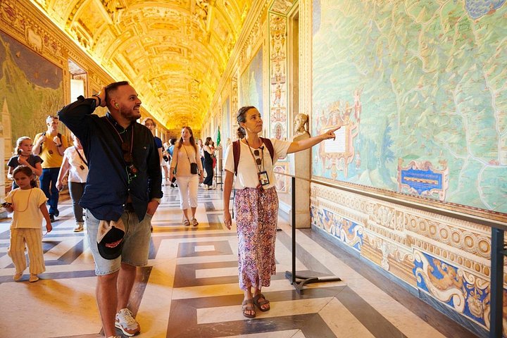 A guide pointing to a wall map in the Vatican Museums