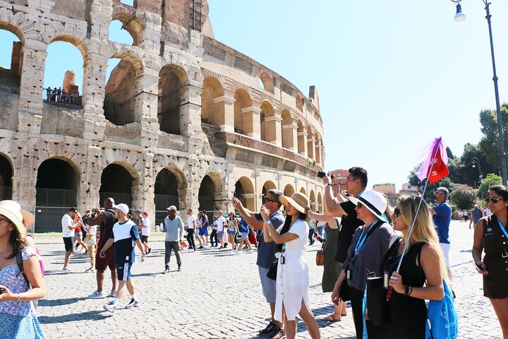 A tour group beside the Colosseum’s outer arches