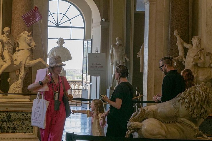 A guide explaining a sculpture to visitors in the Vatican Museums