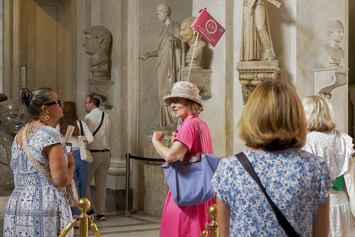 Visitors with a guide in a Vatican Museums sculpture gallery