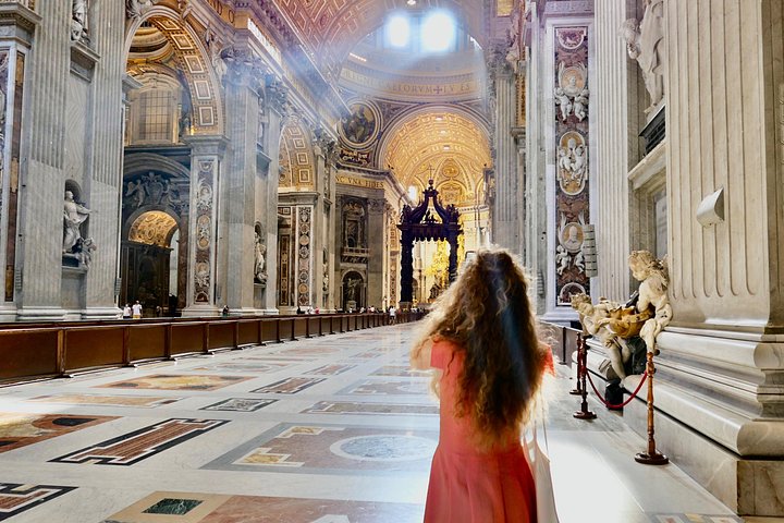 A visitor in the sunlit interior of St. Peter’s Basilica