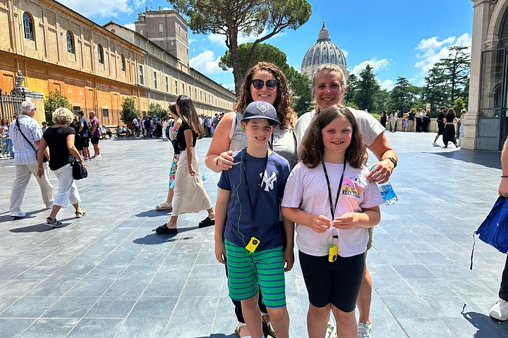 Adults and children in a Vatican Museums courtyard
